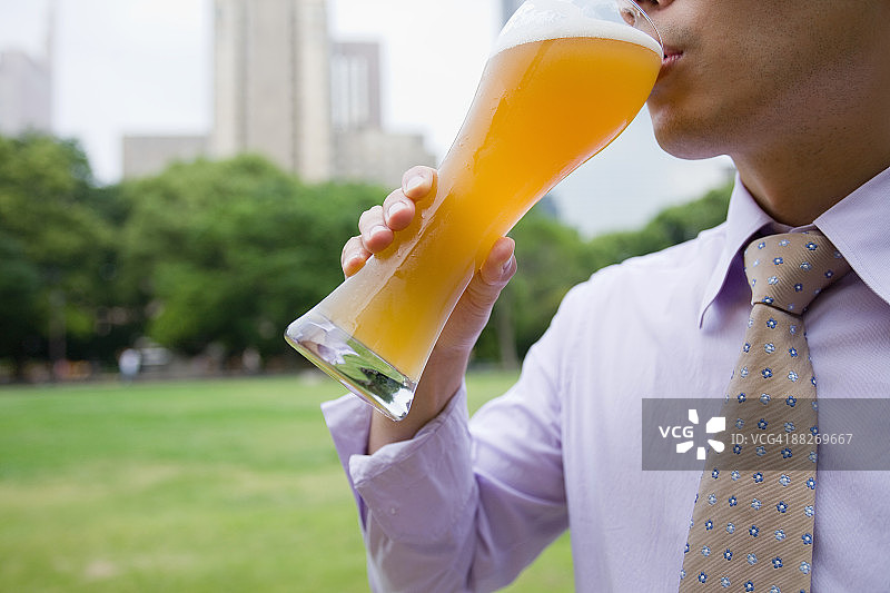 在公园里喝啤酒的商人图片素材