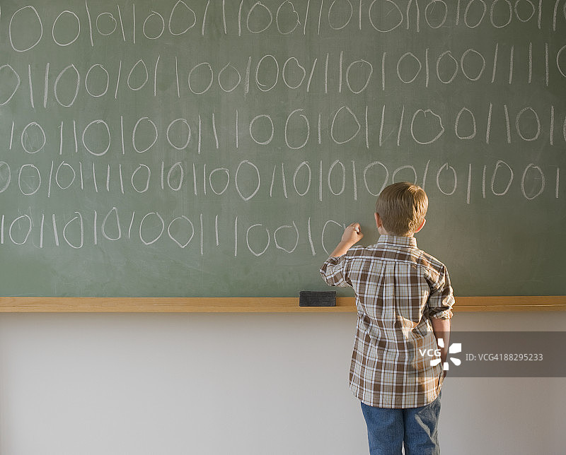 在黑板上书写二进制代码的男孩图片素材