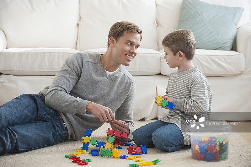 父亲在客厅里和儿子玩耍图片素材