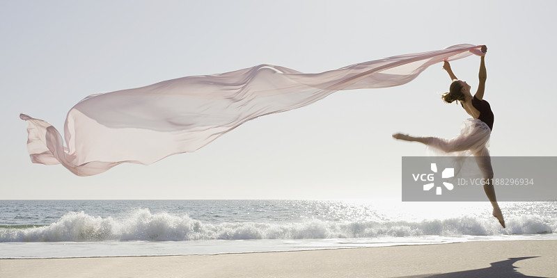 舞者在海滩上跳跃图片素材