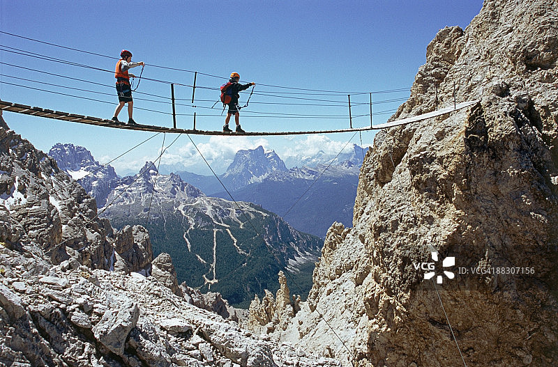 意大利韦内托，克里斯塔洛铁索攀岩道上过桥的儿童图片素材