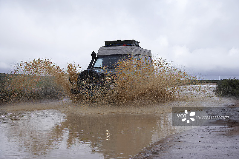 车辆驶过水坑图片素材