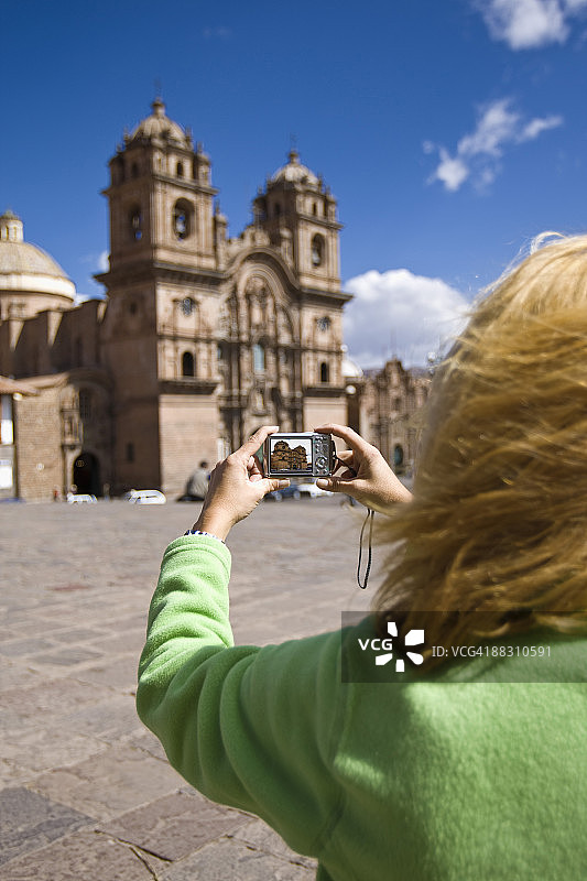 在秘鲁库斯科拍摄耶稣会教堂的女人图片素材