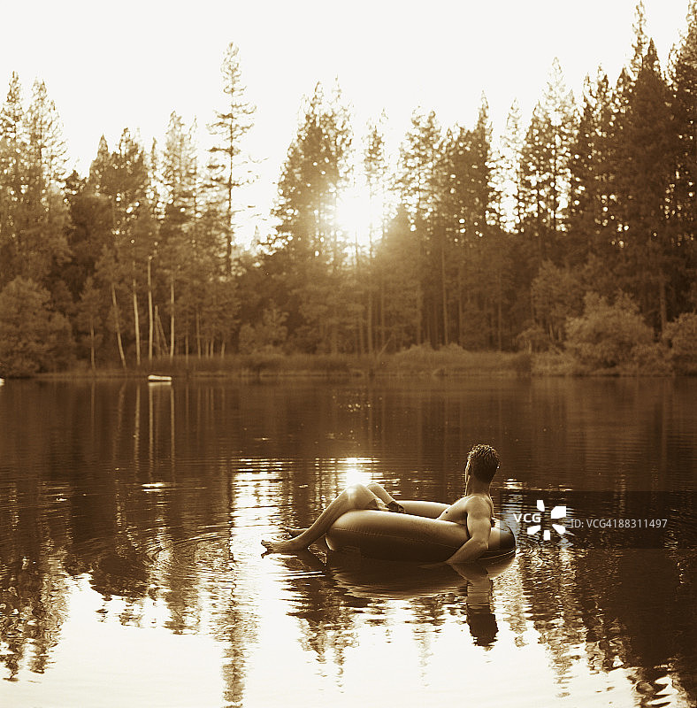 男人在湖面上漂浮在内胎上图片素材