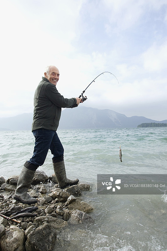 德国巴伐利亚瓦尔兴湖：老年男人在湖中钓鱼图片素材