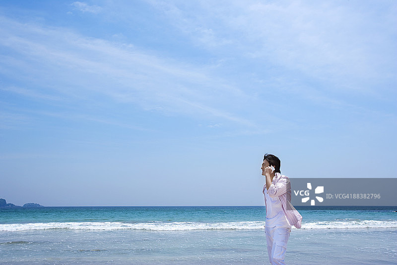 男子在海滩上打电话图片素材