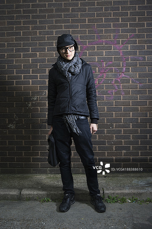 站在墙前的亚洲男人图片素材