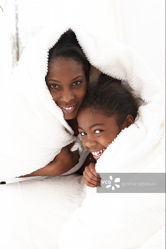 母女俩从毯子下探出头图片素材