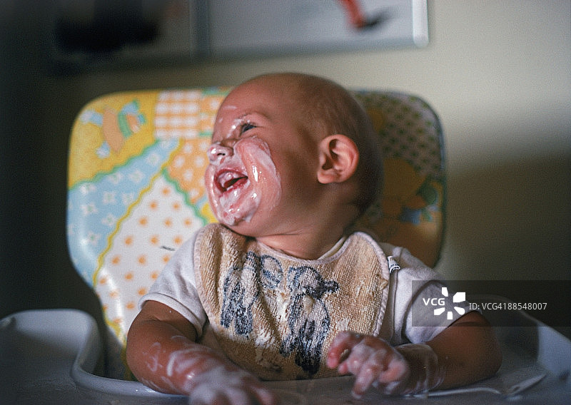 坐在儿童椅上满脸脏污的宝宝图片素材