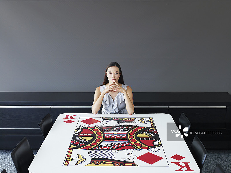 女商人坐在纸牌会议桌旁图片素材