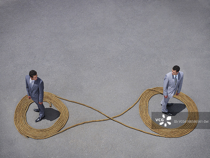 商人站在绳索无限符号中图片素材