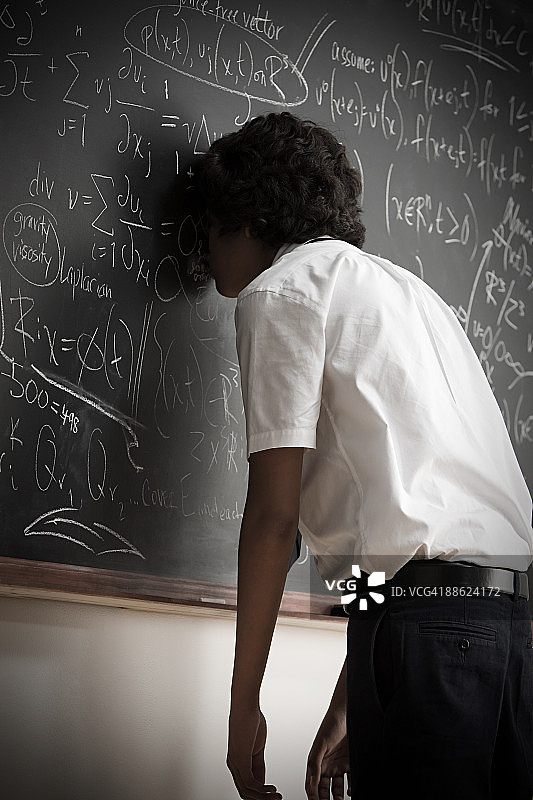男孩倚靠在黑板上图片素材