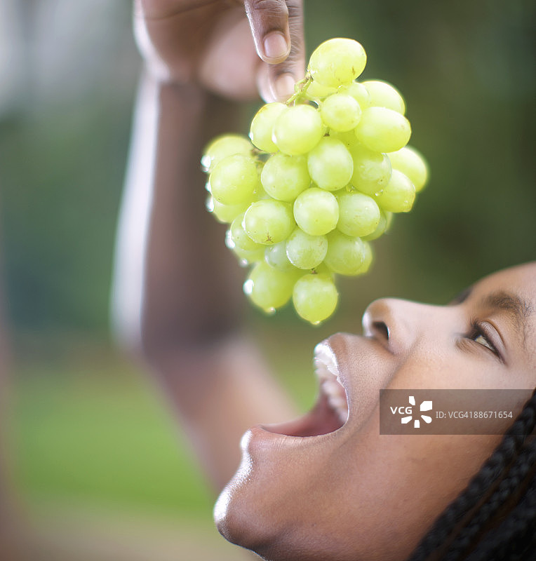 在南非夸祖鲁-纳塔尔省彼得马里茨堡吃葡萄的女人图片素材