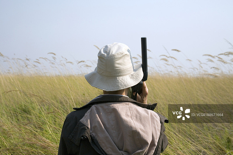 在博茨瓦纳奥卡万戈三角洲用卫星电话交谈的女子的背影图片素材