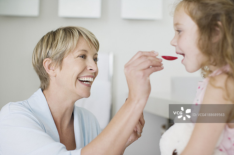 母亲给女儿喂药图片素材