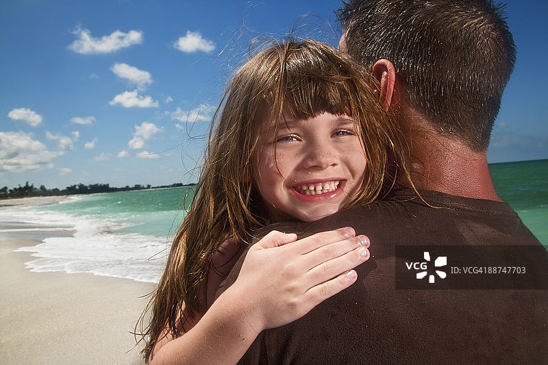 在海滩拥抱父亲的年轻女孩图片素材