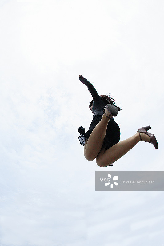 商务女士的低角度视角：跳跃在半空中图片素材
