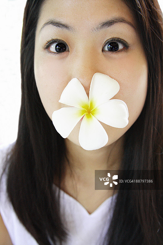 女人口衔鸡蛋花图片素材