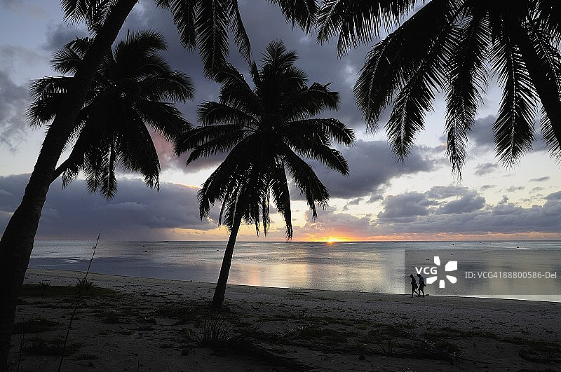 情侣在沙滩上漫步，位于库克群岛艾图塔基岛天堂湾，南太平洋图片素材