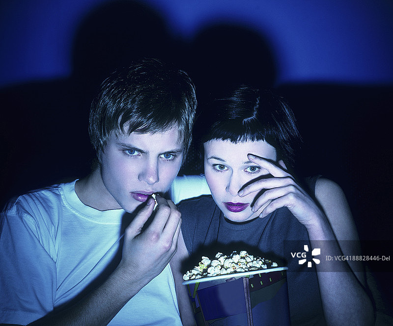 害怕的情侣吃爆米花看电影图片素材