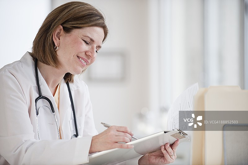 在剪贴板上书写文字的女医生图片素材