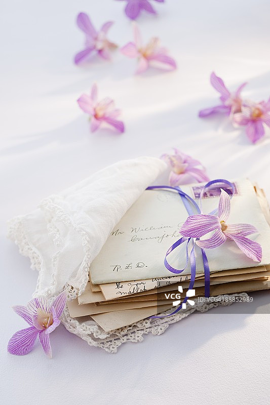 用手帕包裹的旧信件，周围有鲜花图片素材