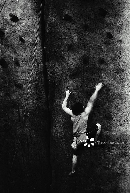 男子在室内攀岩，后视图（黑白）图片素材