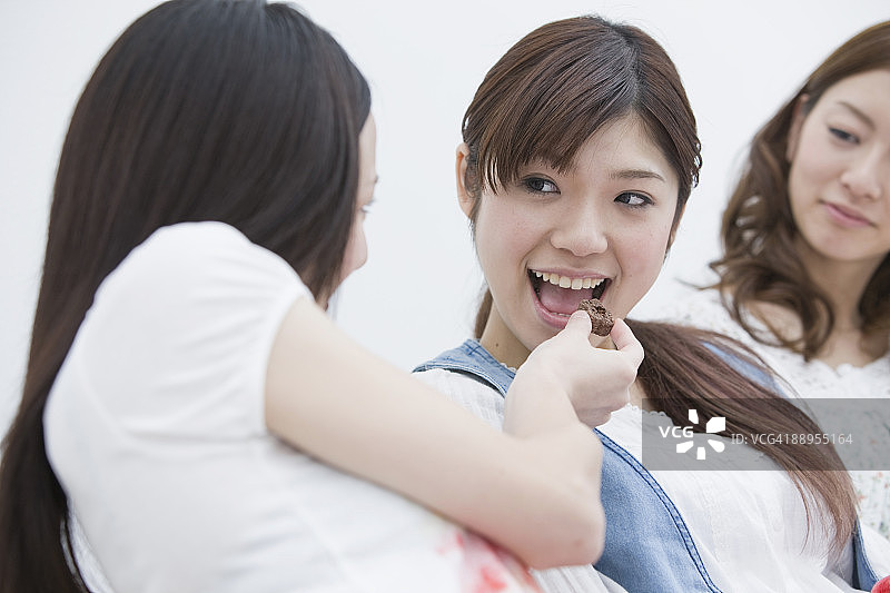 年轻女子给朋友饼干图片素材