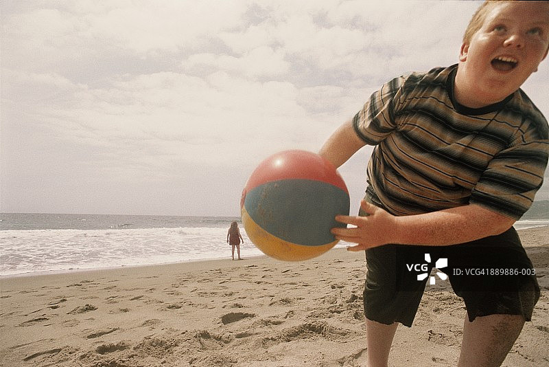 男孩（10-13岁）在海滩上玩球图片素材
