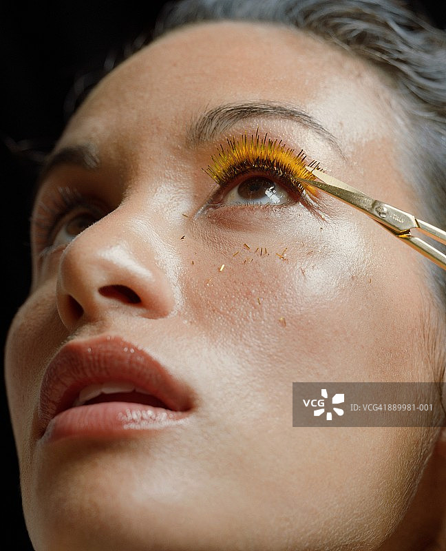 年轻女性修剪假睫毛特写图片素材