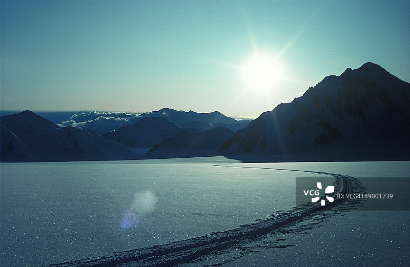 滑雪道穿过雪原通向远山图片素材