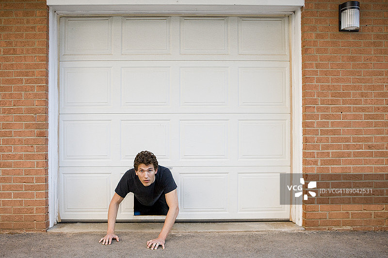 男人卡在宠物门里图片素材