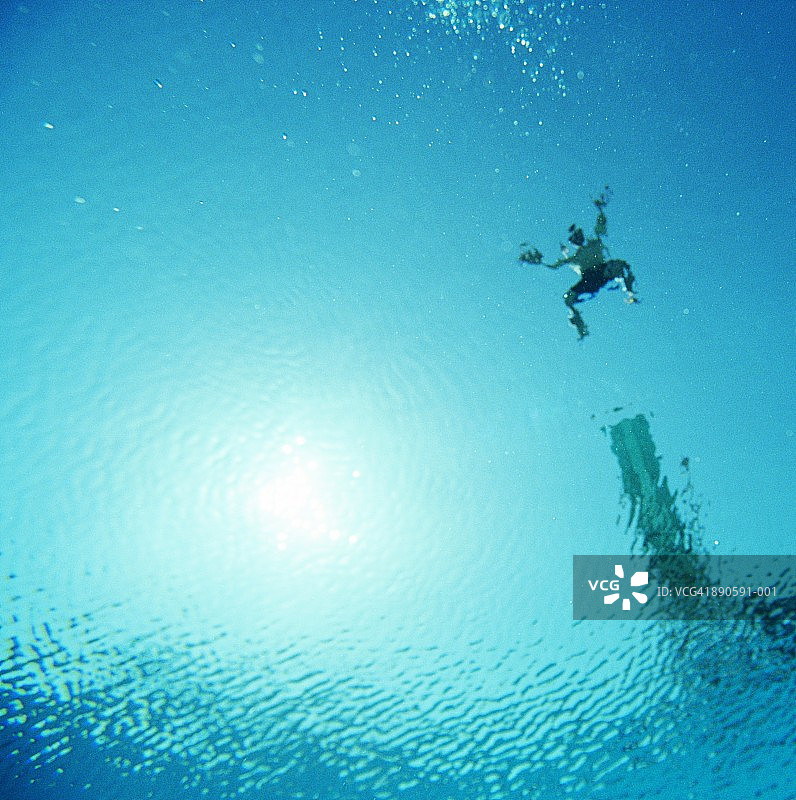 男人从跳水板跳入水中，水下视角图片素材