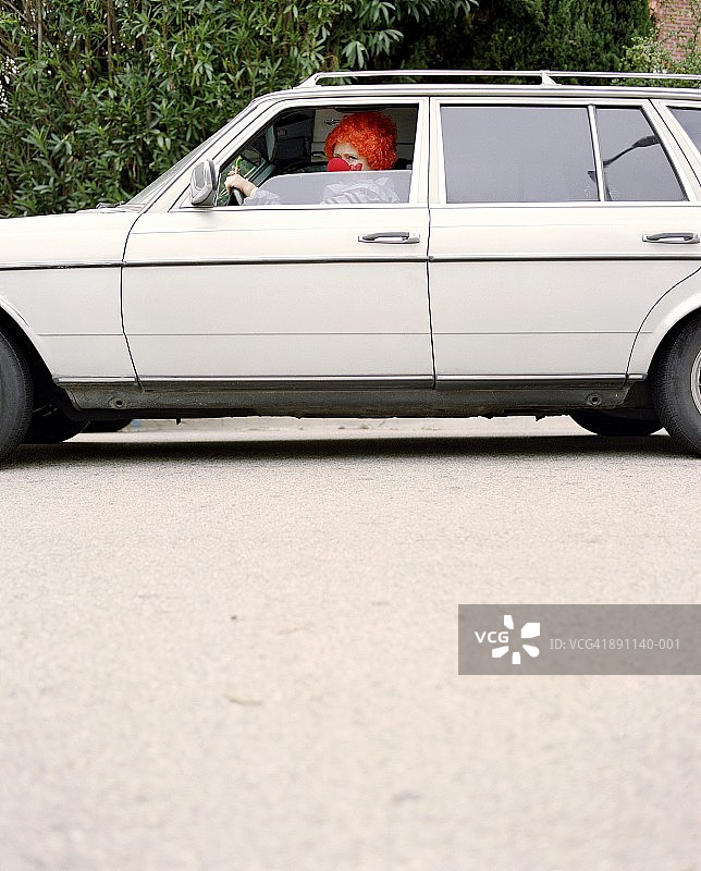 小丑驾驶白色汽车侧视图图片素材