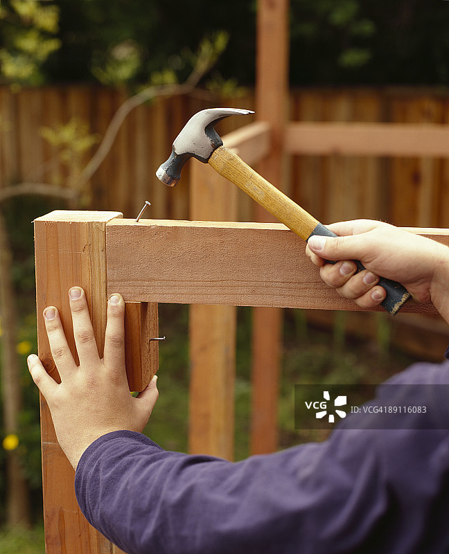 锤子将钉子钉入框架图片素材