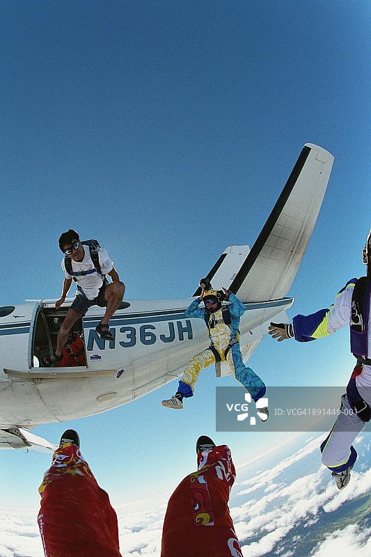 跳伞者离开飞机，男子穿着短裤和凉鞋图片素材