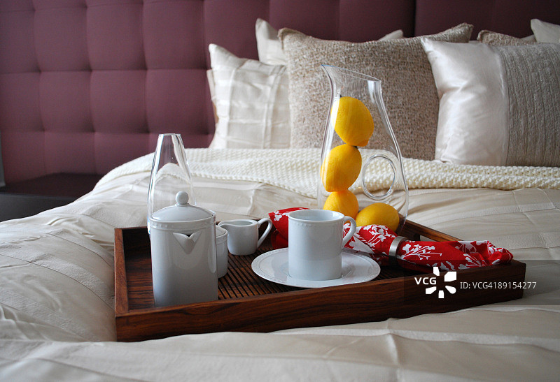 米色和紫色卧室的床上早餐托盘图片素材