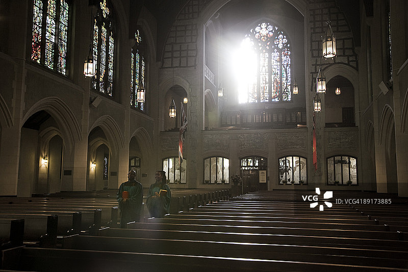 在教堂里拿着圣经行走的男人和女人图片素材