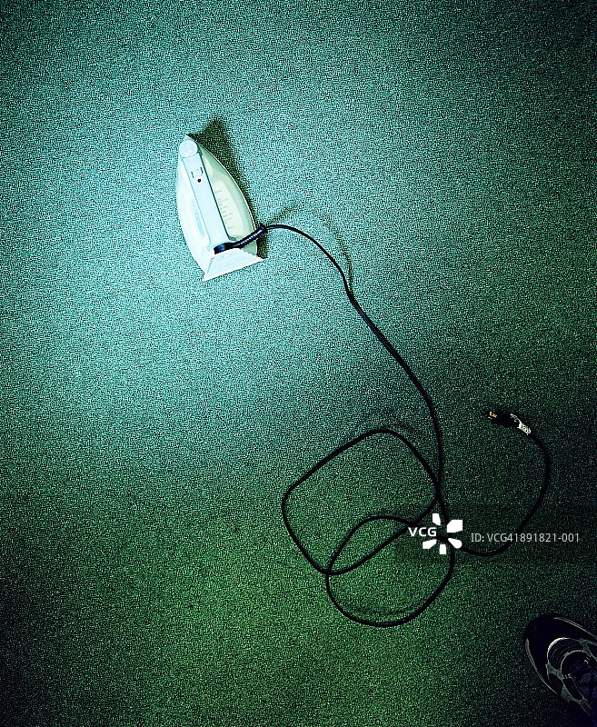 绿色地毯上的熨斗，俯视图图片素材