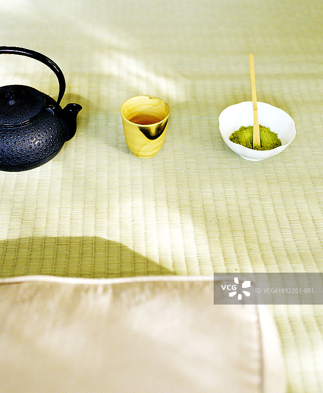 抹茶粉、茶壶和茶杯在席子上排成一列图片素材
