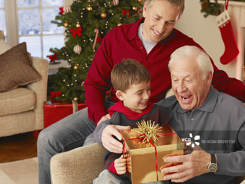 男孩给祖父送圣诞礼物图片素材