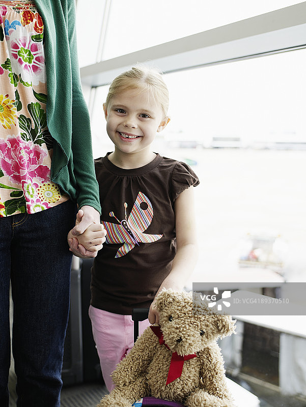 小女孩在机场牵着妈妈的手图片素材