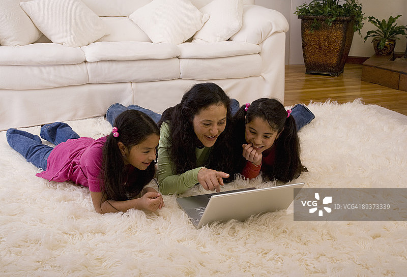 看笔记本电脑的西班牙裔家庭图片素材