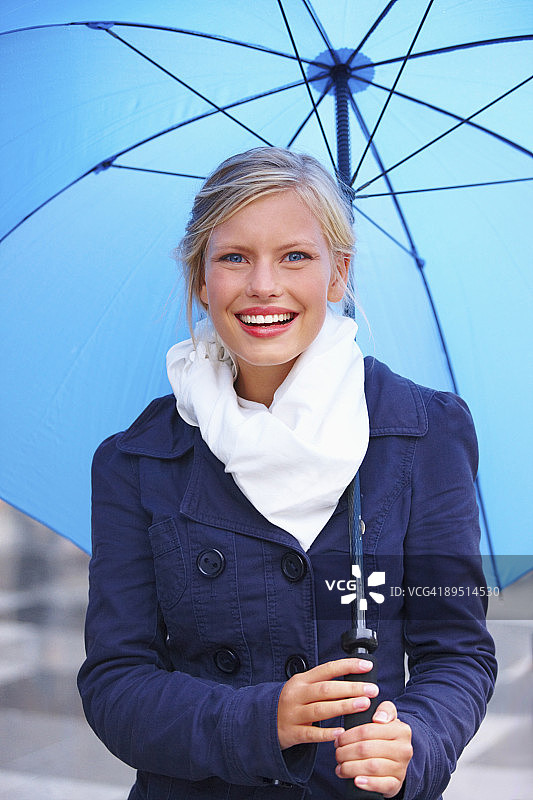 年轻女孩拿着一把蓝色雨伞图片素材