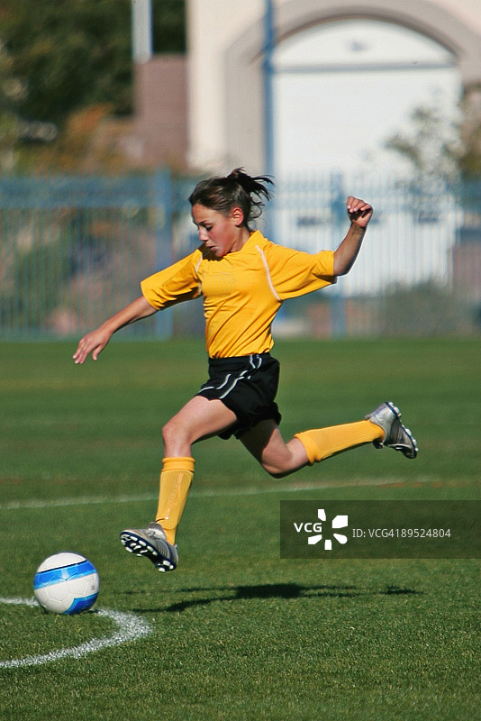 腾空强力一击的年轻女足球运动员图片素材