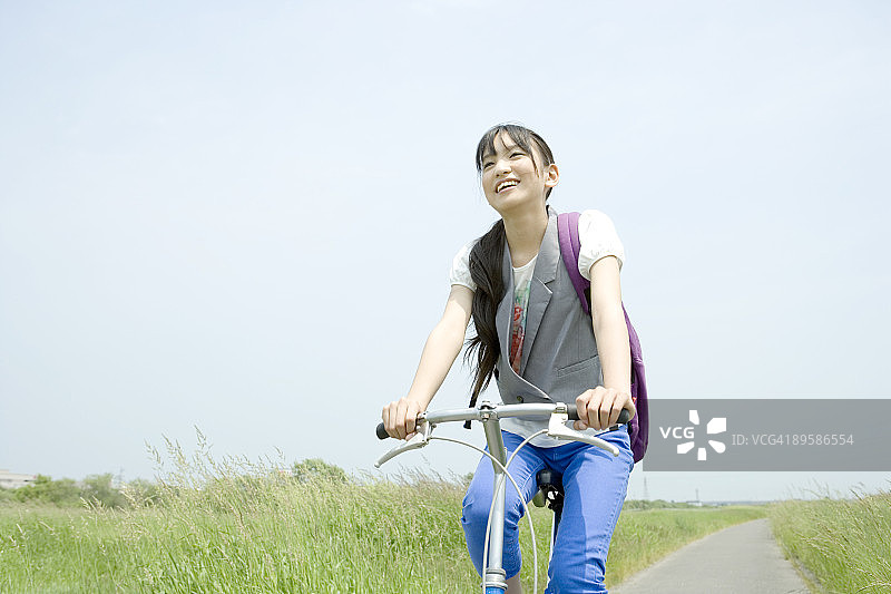 少女骑自行车，面带微笑图片素材