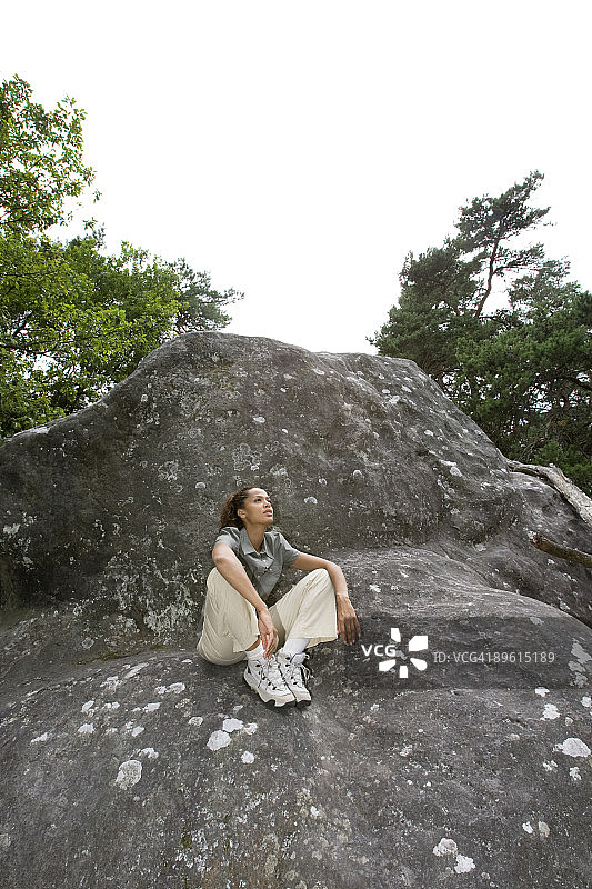 坐在森林岩石上的女人图片素材