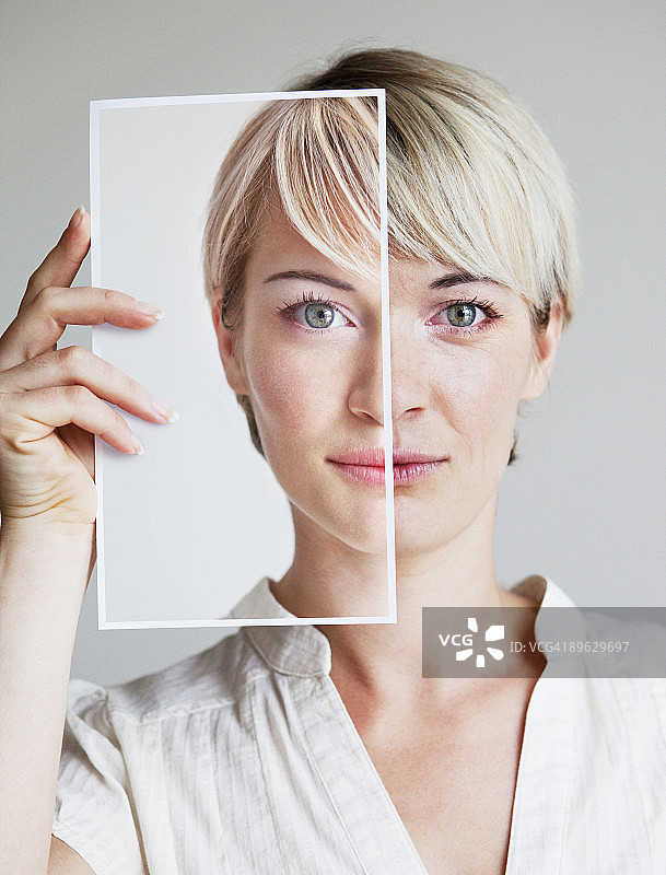 年轻女子手持照片的肖像图片素材