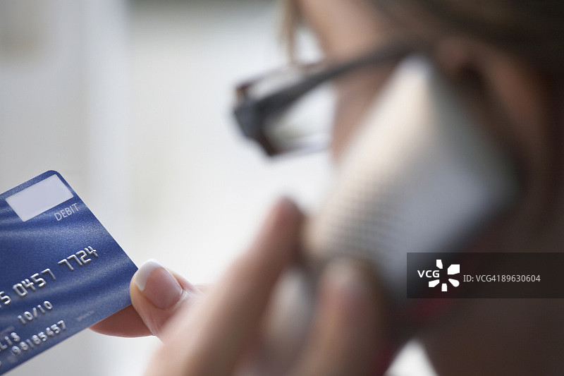 女人打电话并手持借记卡特写图片素材