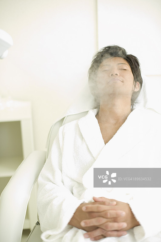 年轻男人接受面部蒸汽美容图片素材